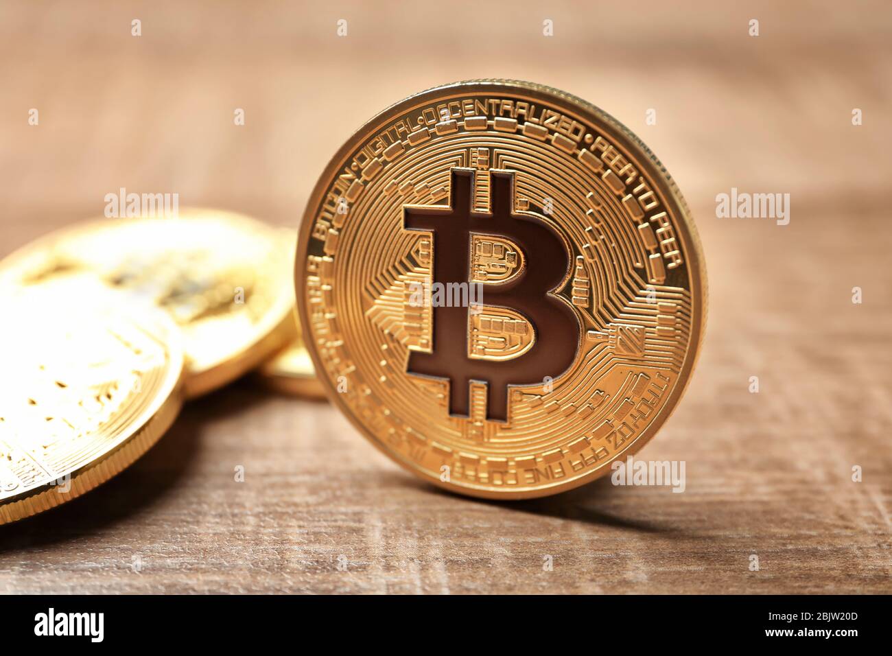 Bitcoins d'oro su sfondo di legno, primo piano Foto Stock