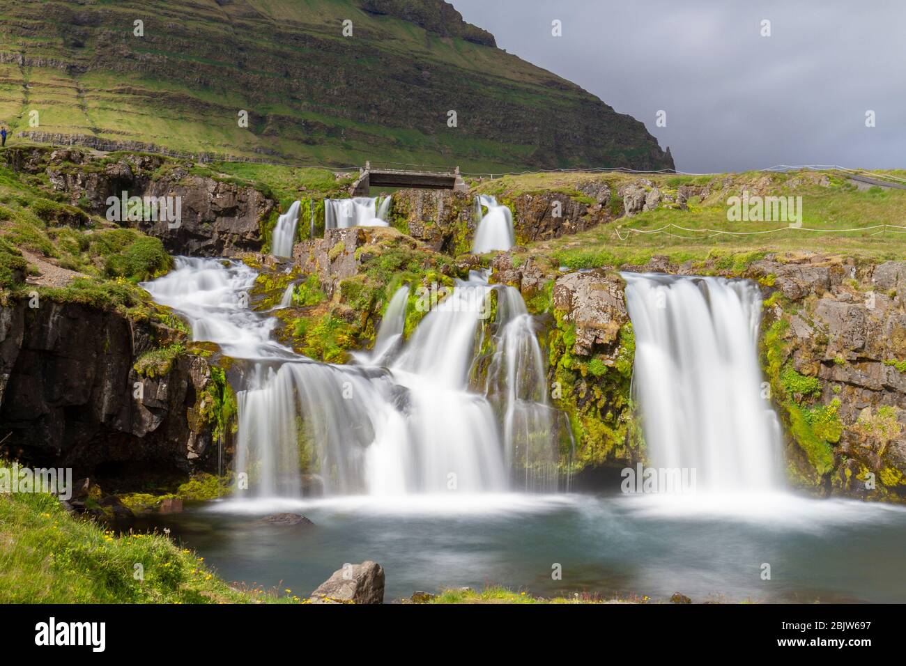 Vista a lunga esposizione della cascata Kirkjufellsfoss che si trova di fronte a Kirkjufell (montagna della Chiesa) sulla penisola di Snæfellsnes, Islanda. Foto Stock