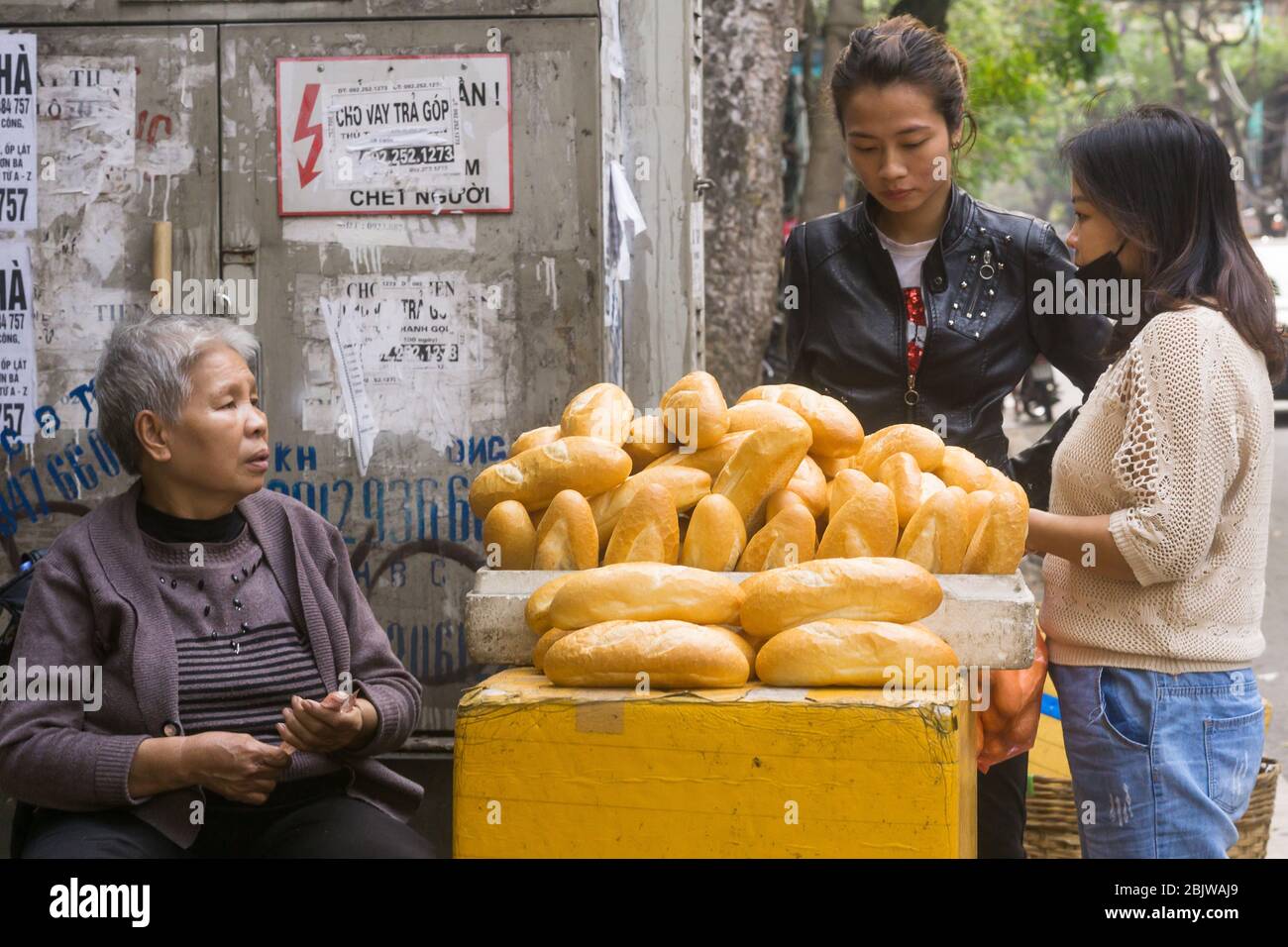 Hanoi pane - un venditore di strada donna che vende loafs di pane in Hanoi, Vietnam, Asia sudorientale. Foto Stock