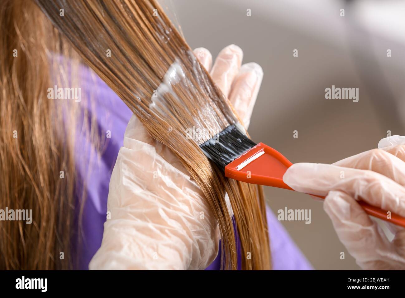 Parrucchiere professionale che muore i capelli del cliente in salone di bellezza, closeup Foto Stock