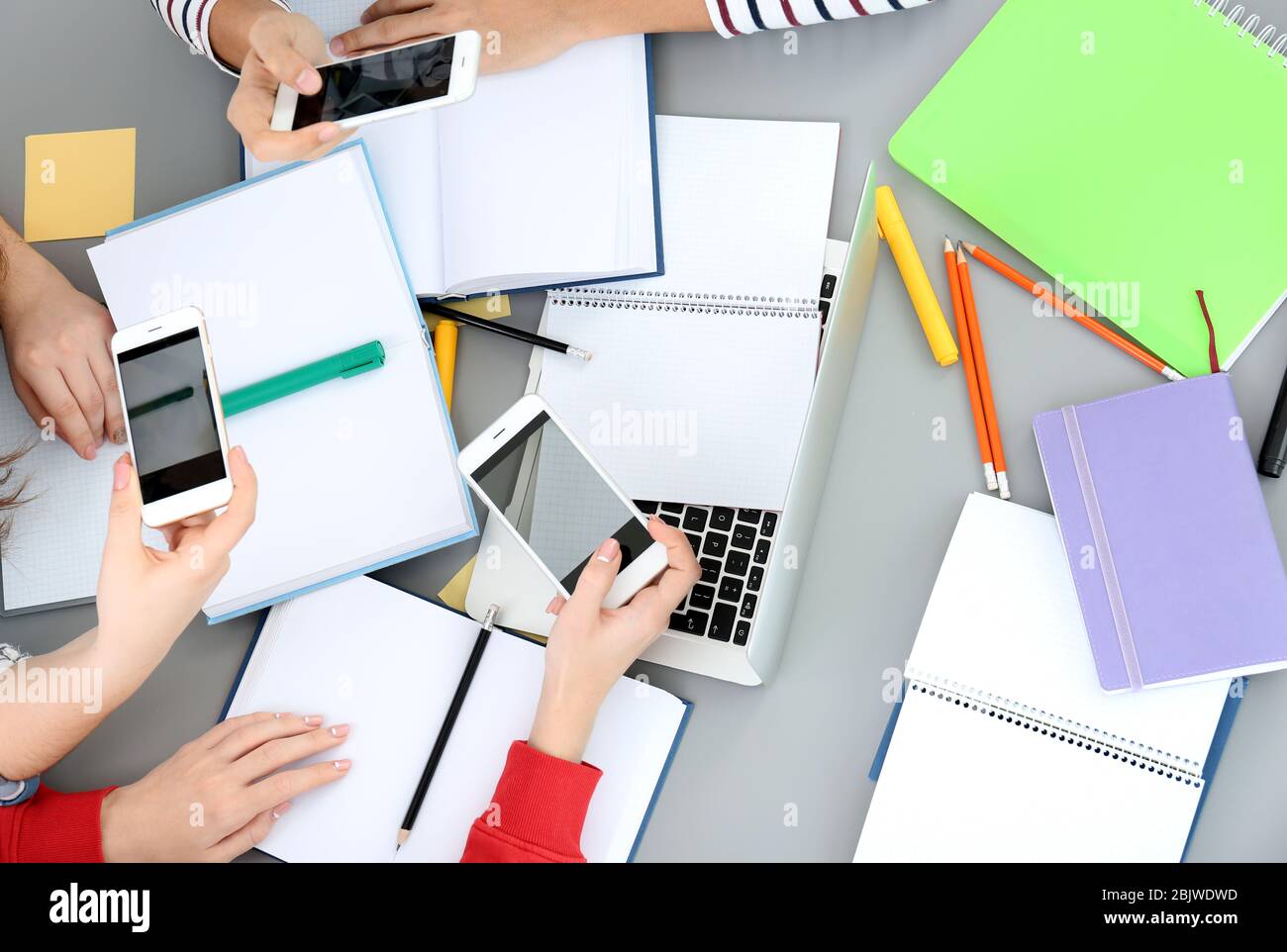 Studenti che fanno fogli di trucco per esami in interni Foto Stock