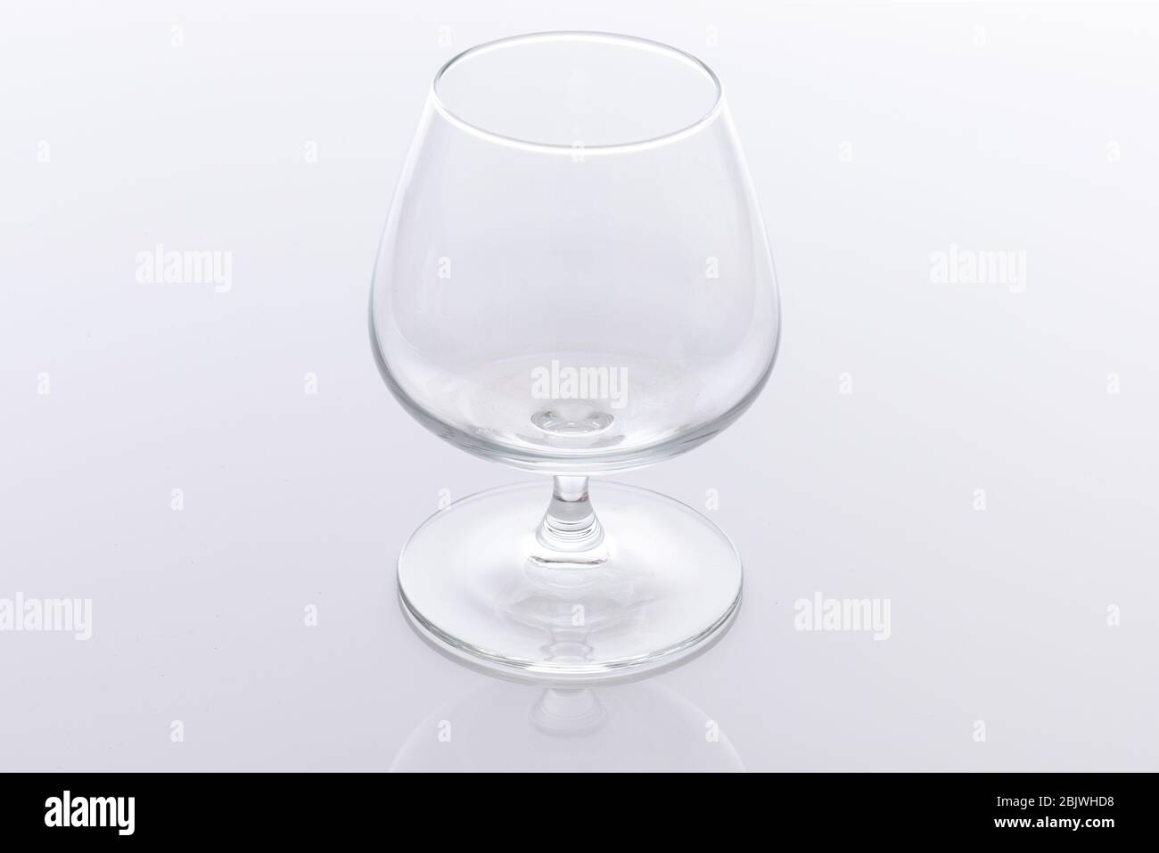 Singolo bicchiere di brandy vuoto isolato su sfondo bianco Foto Stock