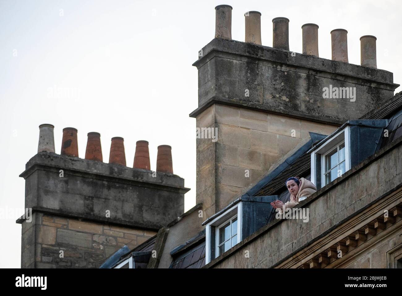 La gente viene alle loro finestre per mostrare il supporto del NHS e dei caregers a Bath, Somerset, durante la pandemia del coronavirus. Foto Stock