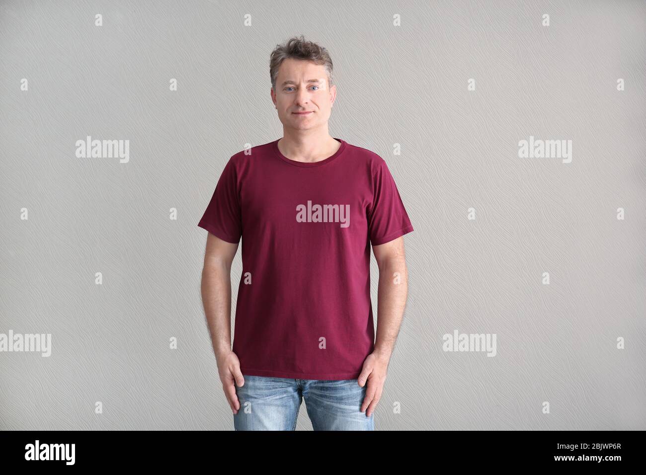 Uomo in t-shirt a colori su sfondo chiaro. Mockup per il design Foto Stock
