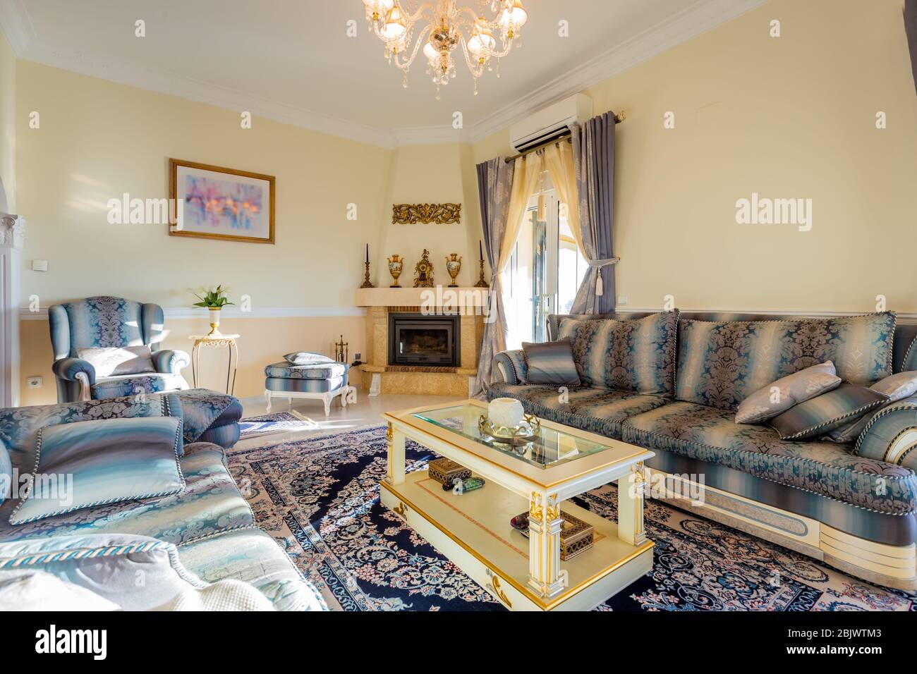 Ampia e accogliente camera da letto in stile classico, mobili beige, tappeti e specchi. Foto Stock