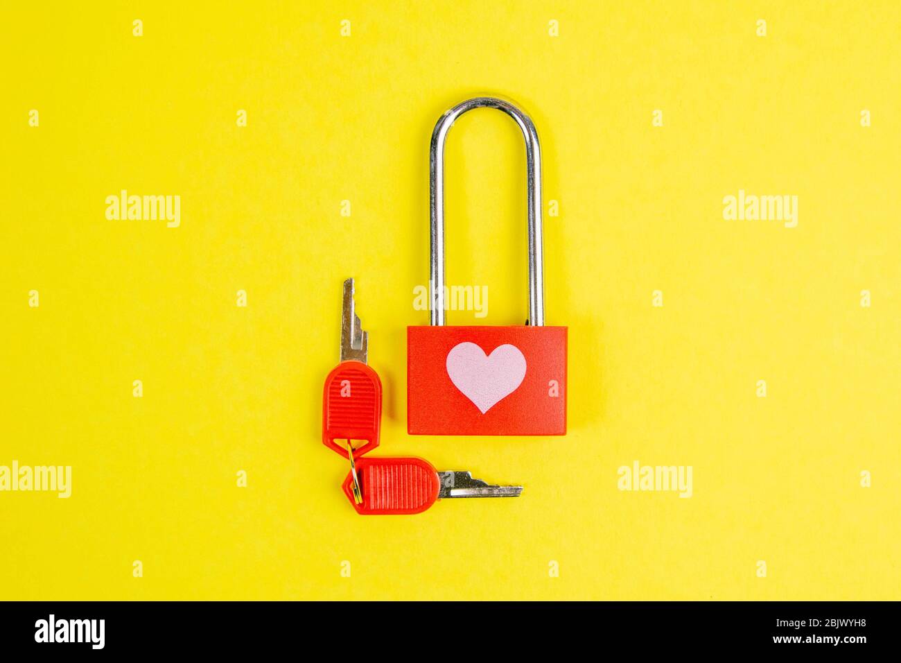 Serratura rossa con cuore di disegno e chiave su yallow background Foto Stock