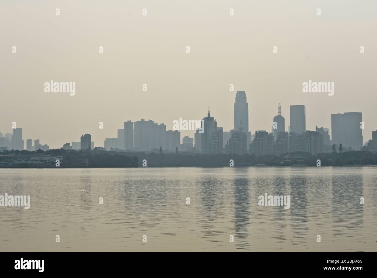 Skyline di Wuhan dal Lago Est, con smog e un cielo nebbia a causa di un inquinamento pesante. Cina Foto Stock