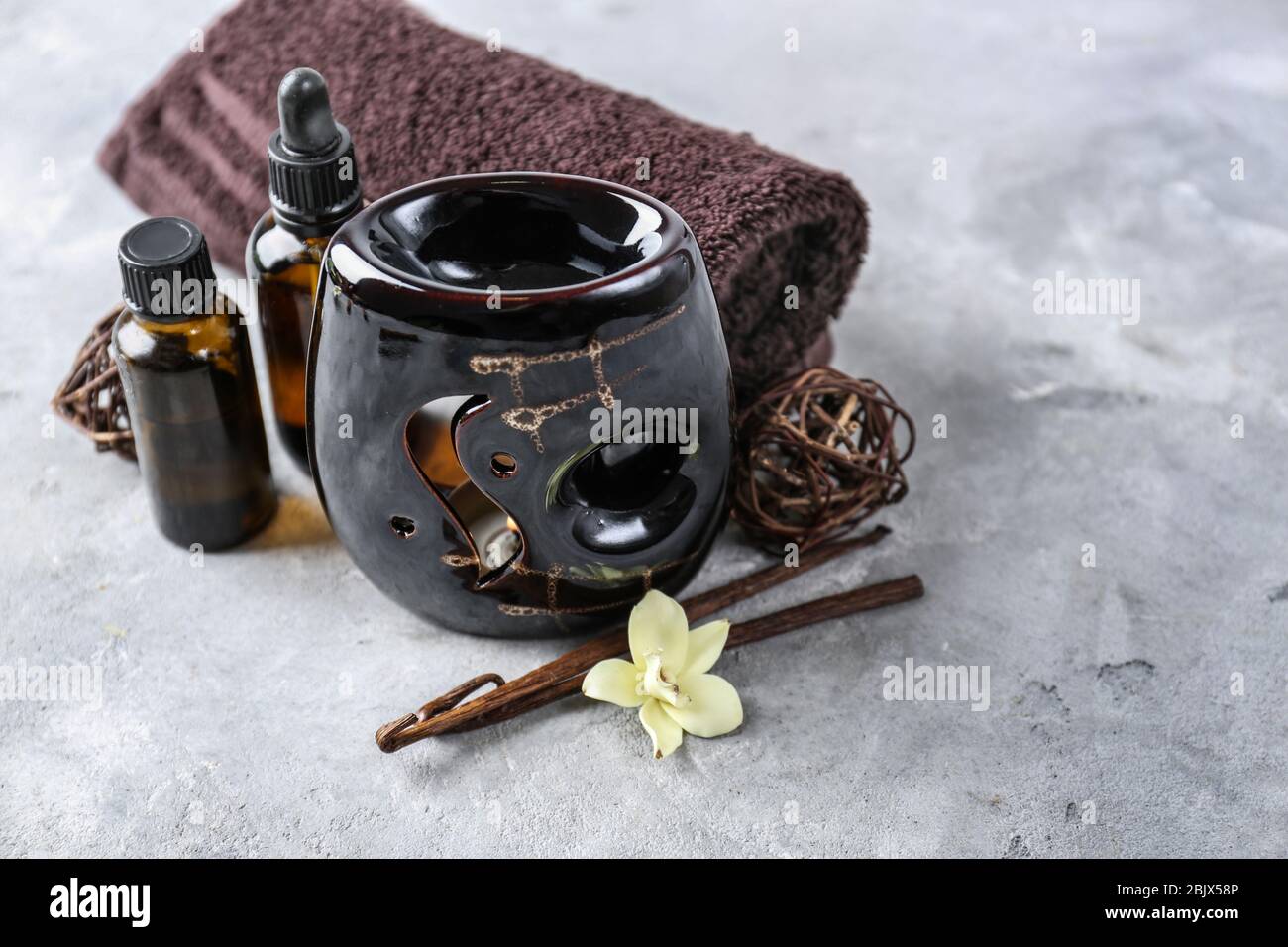 Lampada aromatica, asciugamano e bottiglie d'olio sul tavolo Foto Stock