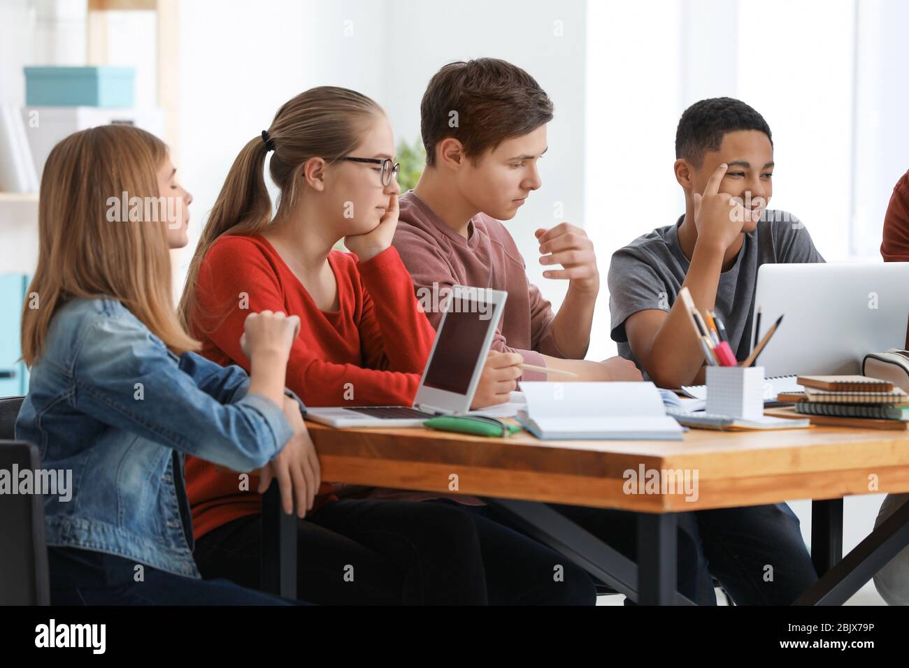 Gruppo di adolescenti che fanno i compiti a tavola Foto Stock