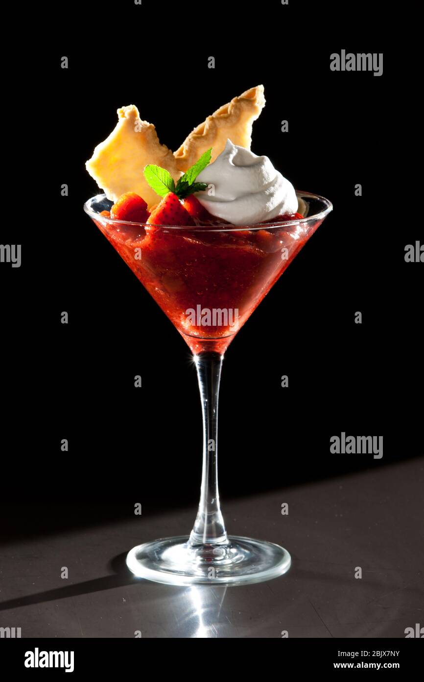 Delizioso dessert fresco e morbido con fragole in bicchiere Martini Foto Stock