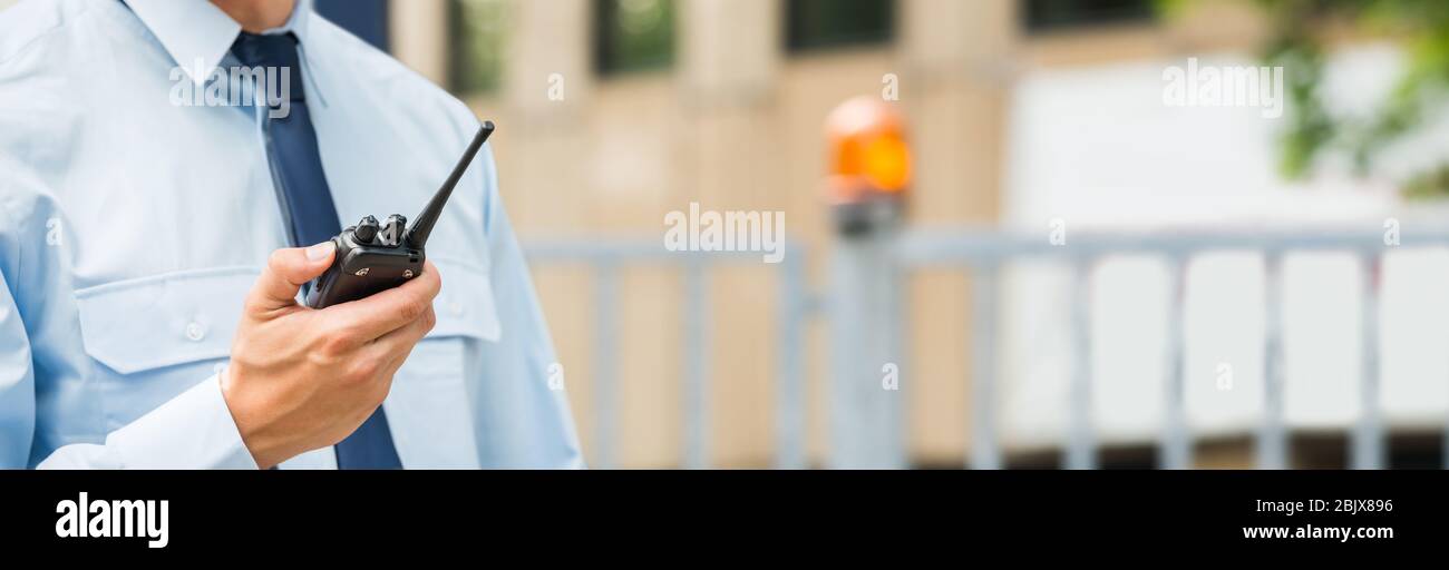 Servizio di sicurezza Guardia uomo tenuta Walkie-Talkie nuovo cancello Foto Stock