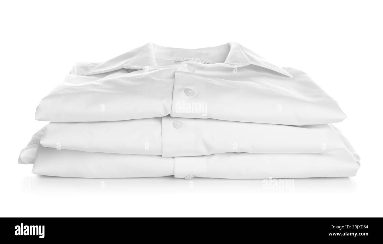 Pile di camicie piegate pulite su sfondo bianco. Giorno di lavanderia Foto Stock