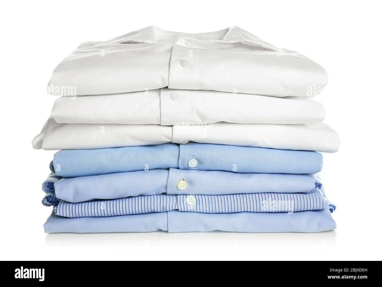 Pile di camicie piegate pulite su sfondo bianco. Giorno di lavanderia Foto Stock