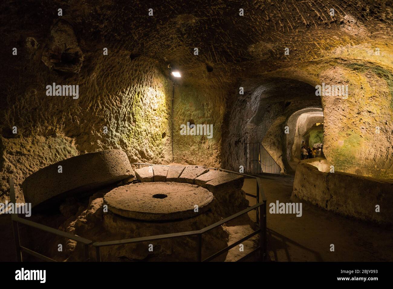 Frantoio e passaggi scolpiti nella superficie vulcanica del tufo nelle camere sotterranee risalenti all'epoca etrusca, quando la gente voleva una fuga Foto Stock