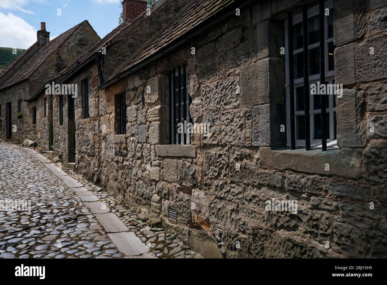 Edifici in pietra e la strada acciottolata stretta a Falkland, Fife, Scozia, Regno Unito, Europa Foto Stock
