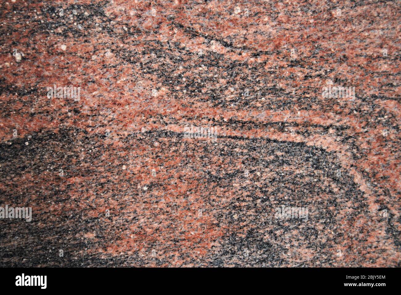 Primo piano di una superficie in granito lucido di tipo rosso multicolore utile per alcuni sfondo marmorizzato Foto Stock