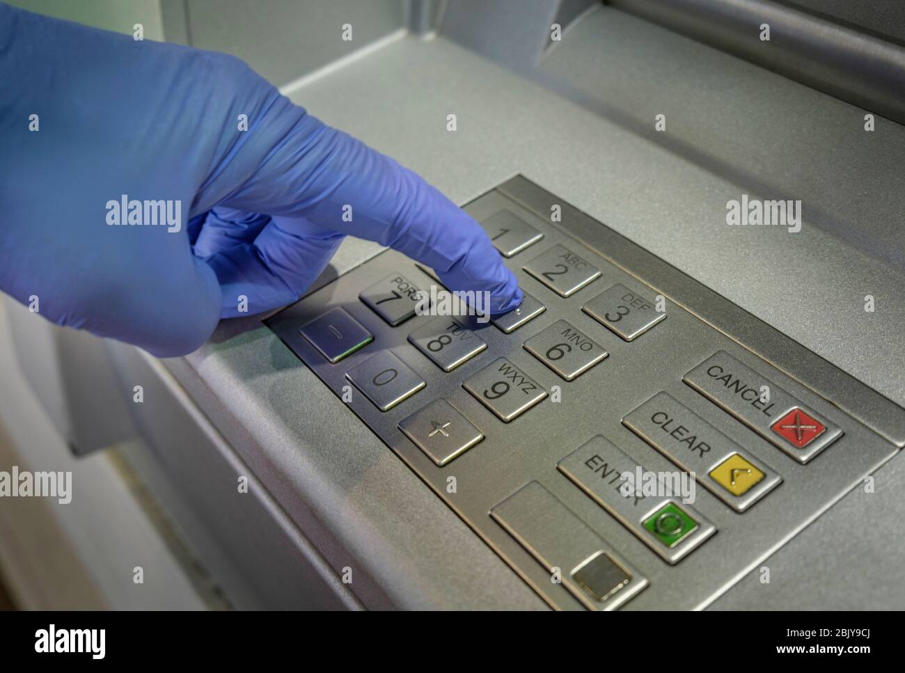Pulsante a mano con guanti della macchina per il contante Foto Stock