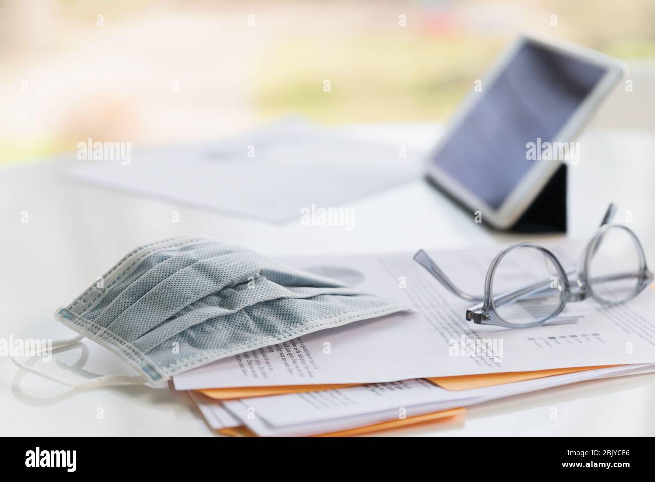 Maschera facciale su business paper e tablet Foto Stock