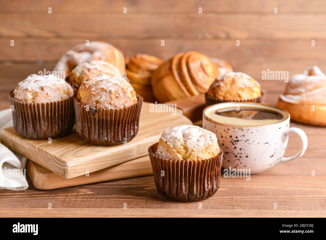 Gustosi muffin con tazza di caffè sul tavolo in legno Foto Stock