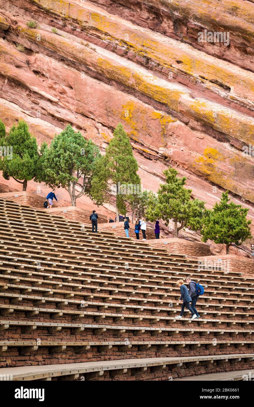 I turisti salgono i gradini dell'iconico Red Rocks Amphitheater appena fuori Denver, Colorado, USA. Foto Stock