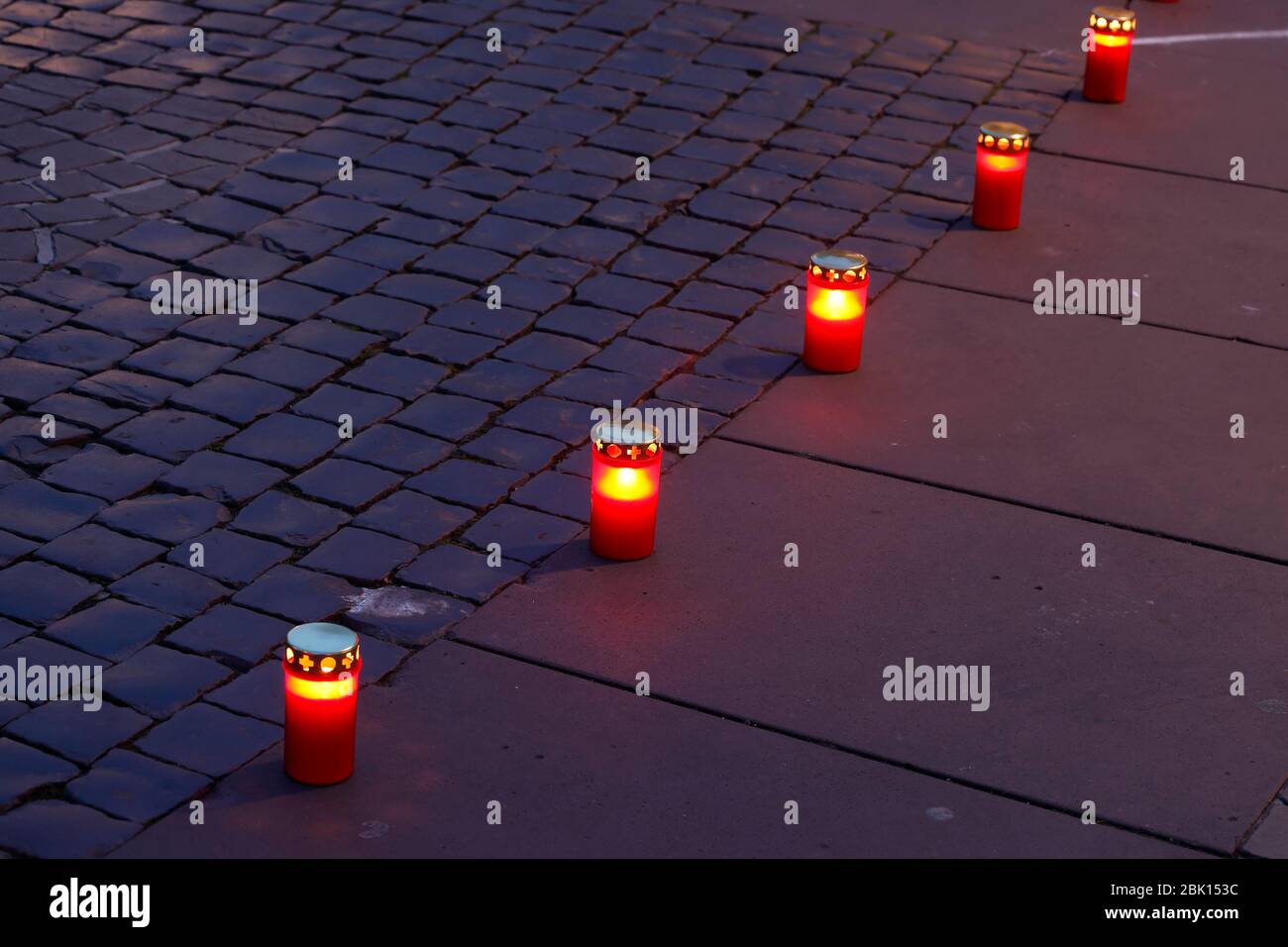 Luci di tomba, candele rosse allineate sul marciapiede di notte, Germania Foto Stock