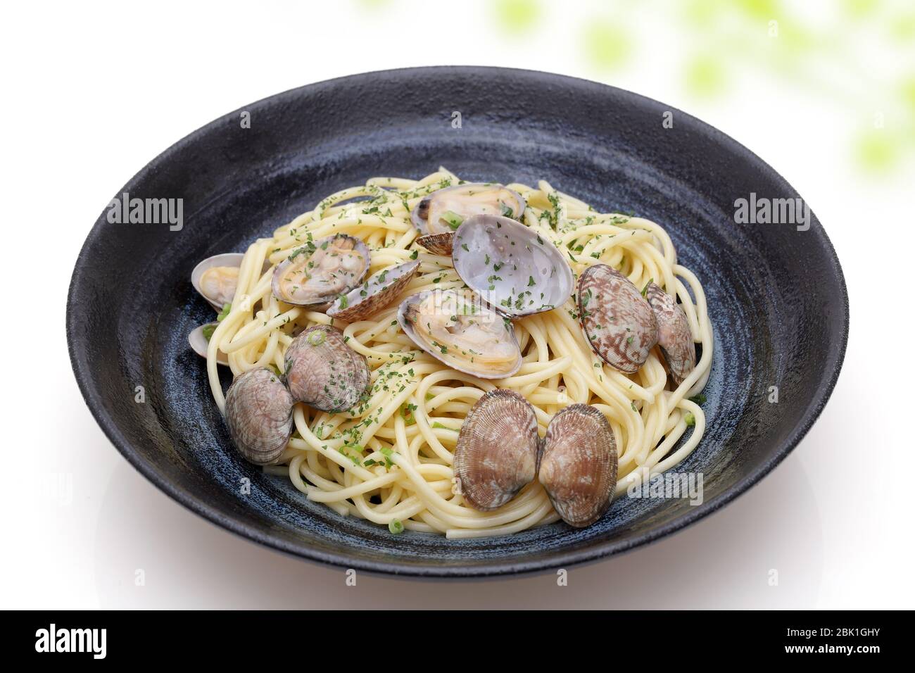 Spaghetti di vongole in un piatto su sfondo bianco Foto Stock