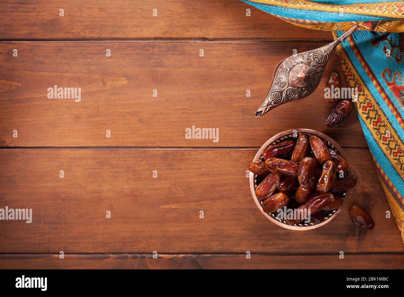 Piastra in bronzo con datteri e lampada aladdin su vecchio tavolo in legno. Ramadan sfondo. Ramadan Kareem. Messa a fuoco selettiva. Foto Stock