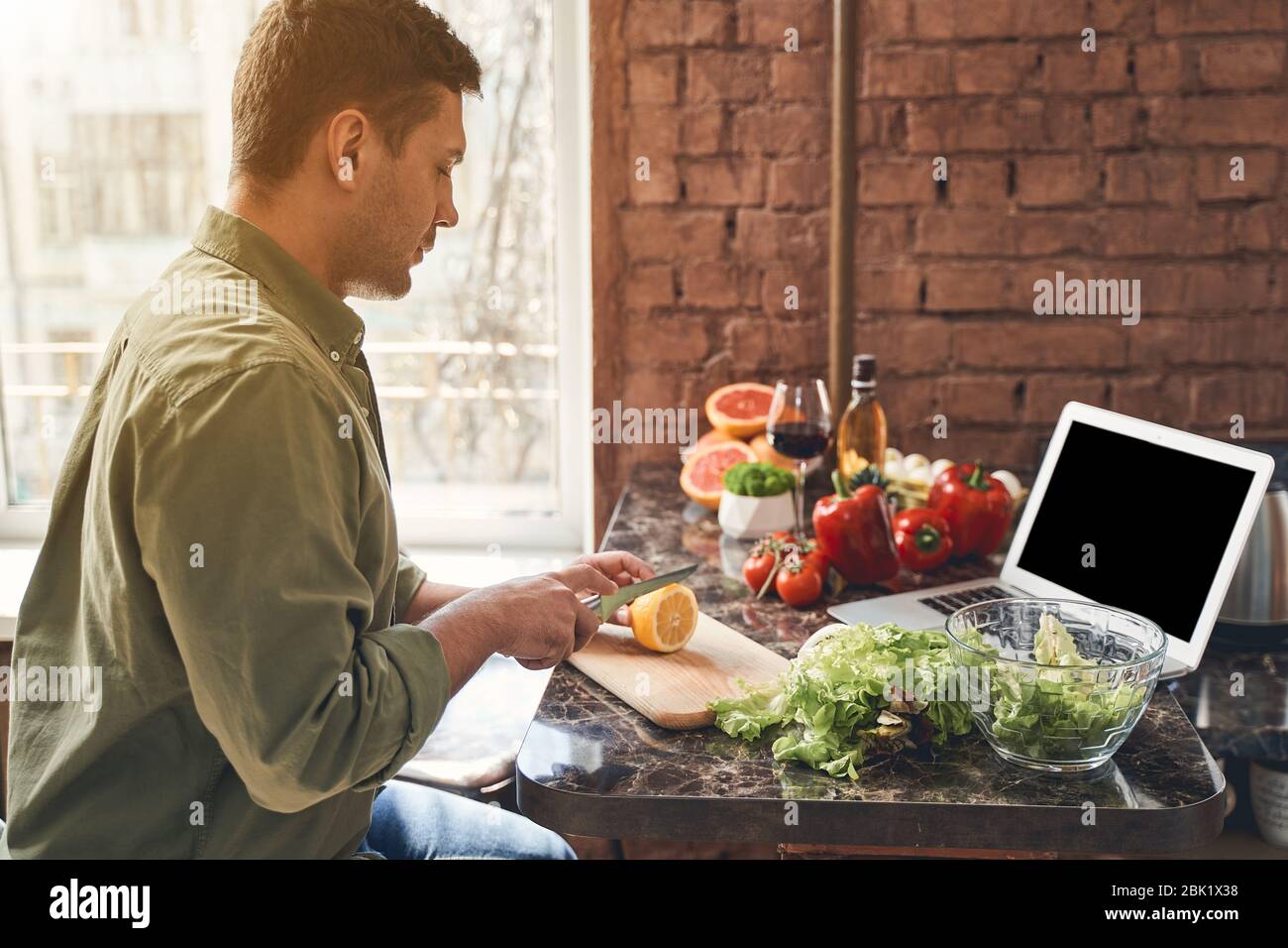 Uomo seduto ad un tavolo da cucina in marmo Foto Stock