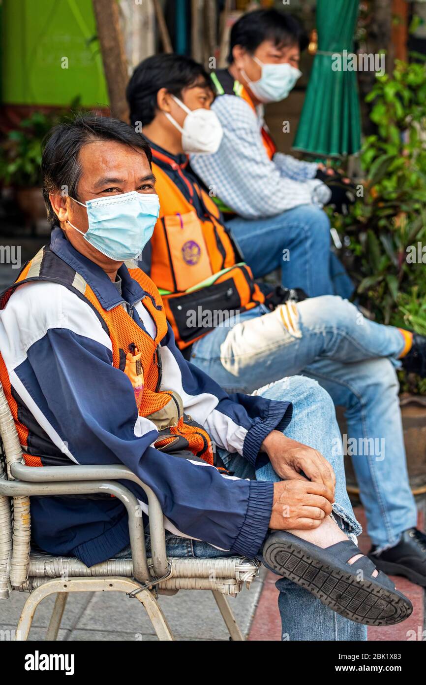 Motociclisti con maschere in attesa per i passeggeri durante la pandemia Covid 19, Bangkok, Thailandia Foto Stock