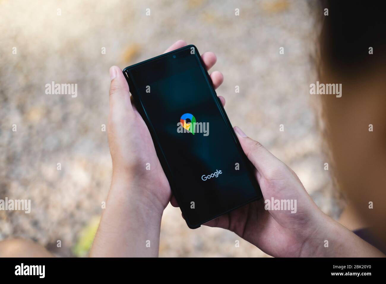 RAYONG, THAILANDIA, Apr 12,2020: Un uomo che detiene Samsung Galaxy Note smartphone per l'uso di Google Maps applicazione che nuovo logo al bar. Google Maps Foto Stock