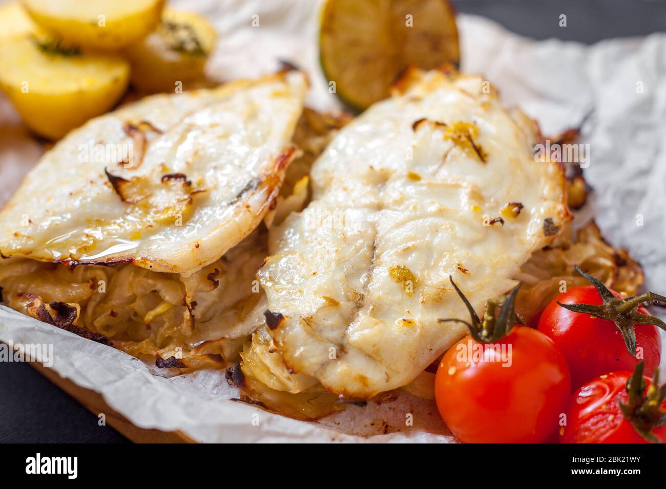 Filetto di pesce bianco con pomodori ciliegini e patate Foto Stock