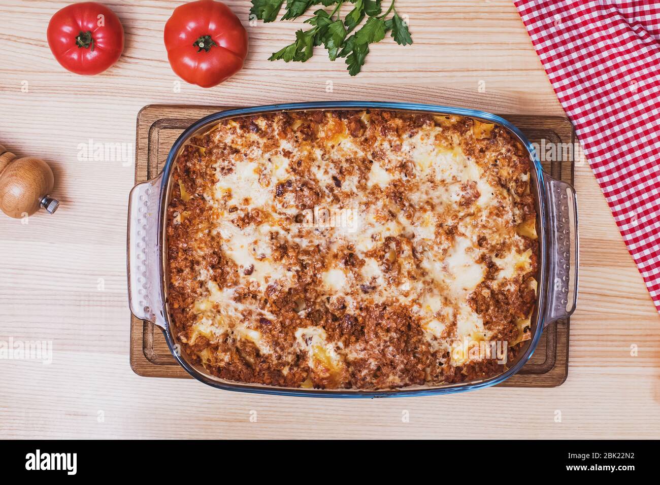 Vista dall'alto di una deliziosa lasagna tradizionale italiana fatta con salsa di bolognese di manzo tritato su tavolo di legno Foto Stock