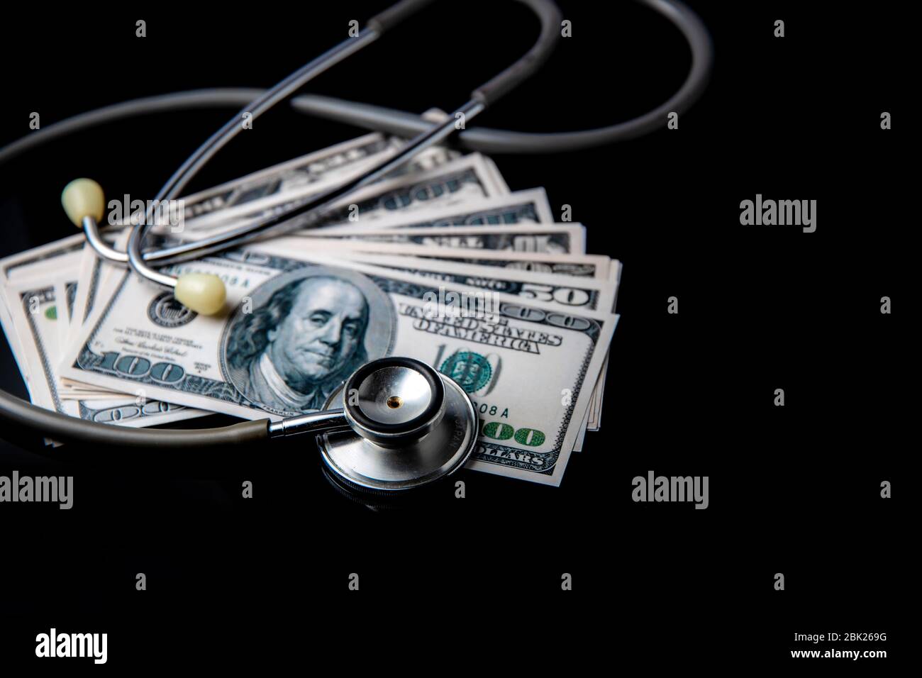 Concetto di economia crisi e recessione negli Stati Uniti durante coronavirus o covid-19 pandemic dollari USA stetoscopio e sfondo nero Foto Stock