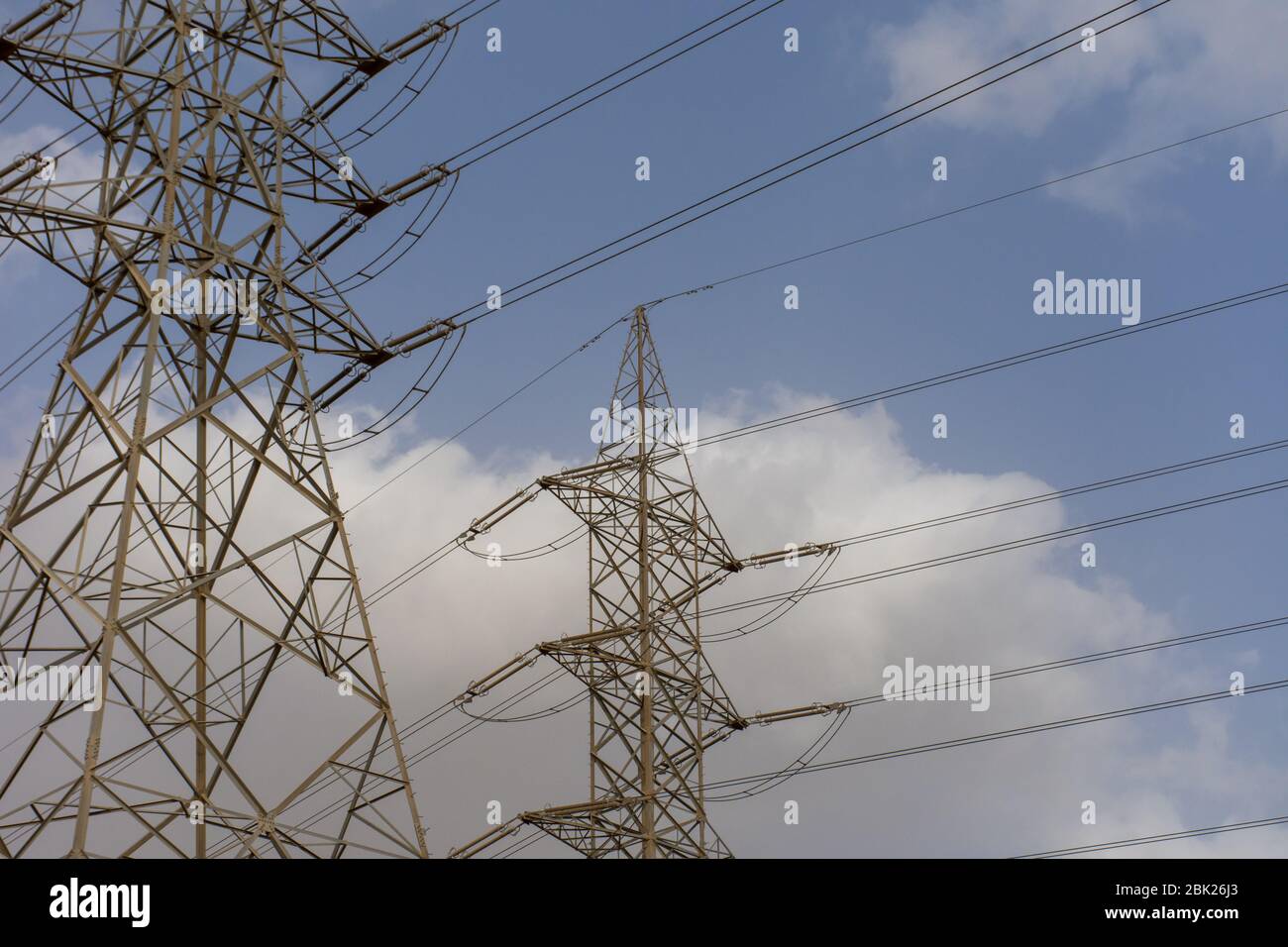 Linee elettriche ad alta tensione su cielo blu e sfondo nuvoloso nel medio Oriente. Foto Stock