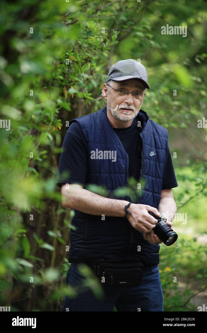 Uomo con macchina fotografica nella foresta. Foto Stock