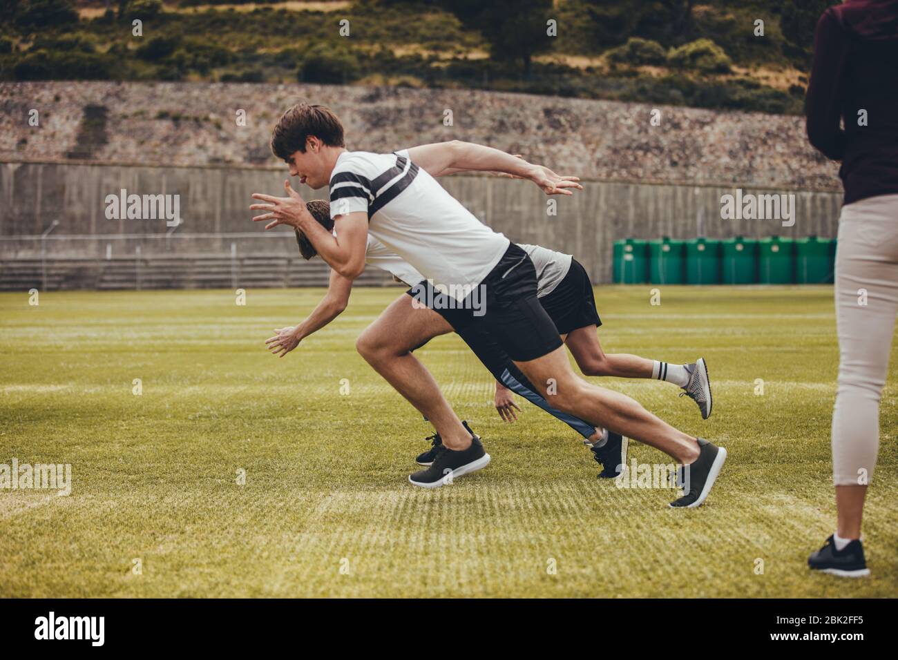 Gara di corsa per ragazzi al parco giochi della scuola. Gruppo di studenti che si esercitano per la giornata sportiva annuale presso la scuola superiore. Foto Stock