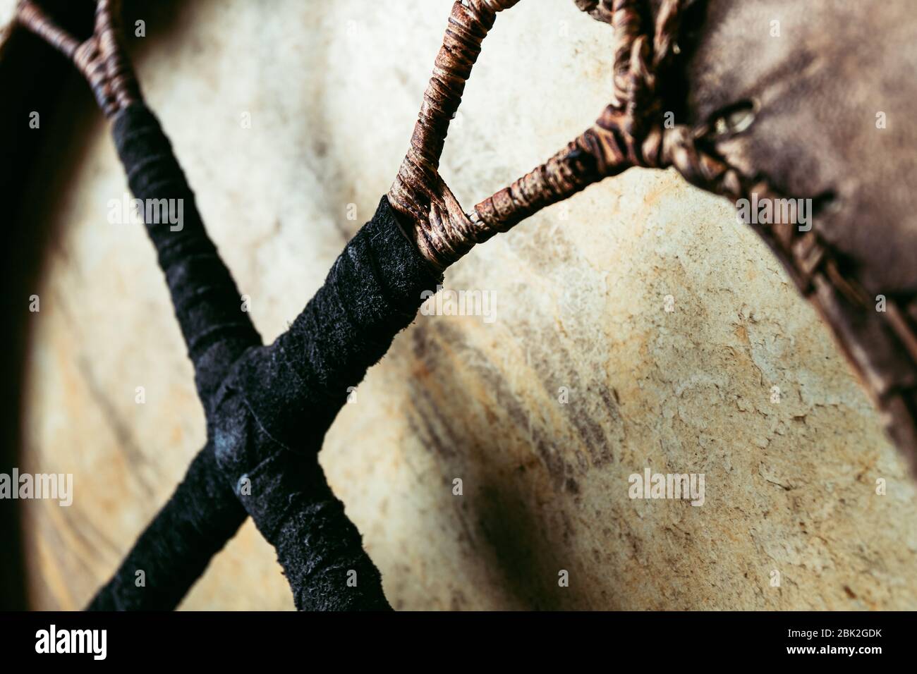 Dettagli del tamburello sciamanico. Maniglia intrecciata in pelle, vista ravvicinata realizzata a mano. Foto Stock