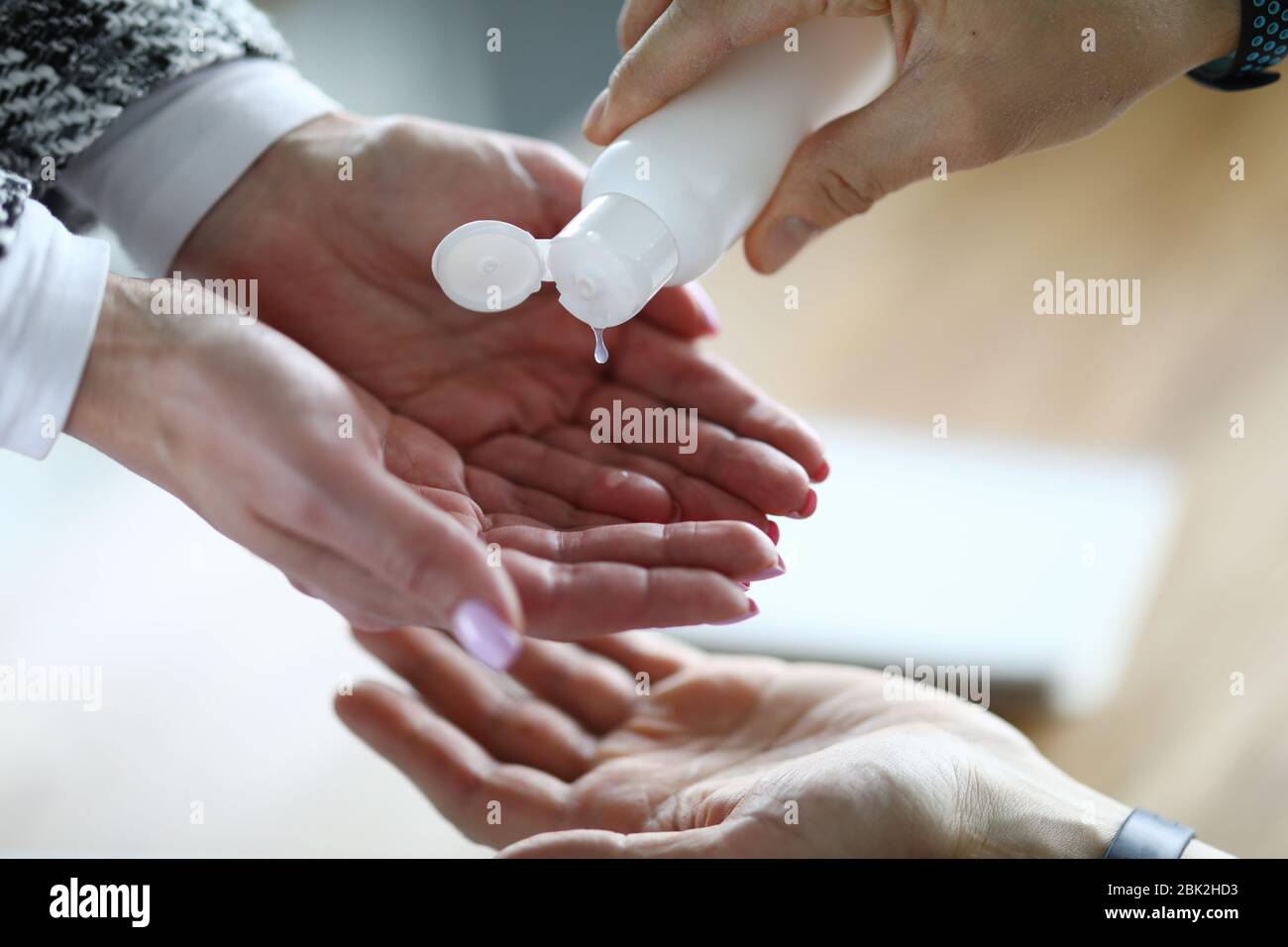 Donna che applica antisettico per pulire le mani Foto Stock