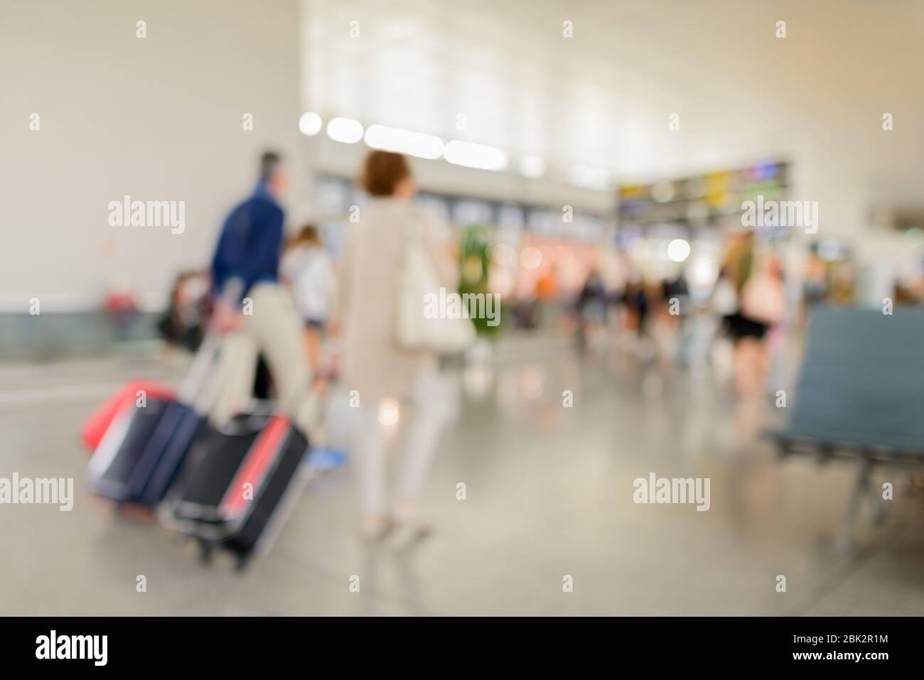 Check-in di partenza al terminal con defocused all'aeroporto con viaggiatori a piedi Foto Stock
