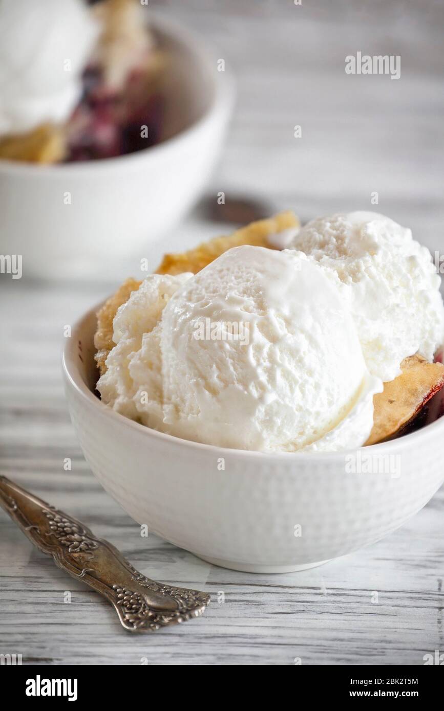 Ciottoli di ciliegia fatti in casa con due cucchiai di gelato alla vaniglia. Messa a fuoco selettiva con sfondo sfocato. Foto Stock