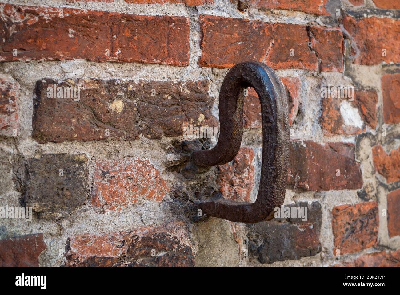 Vecchio gancio di ferro in un muro di mattoni Foto Stock