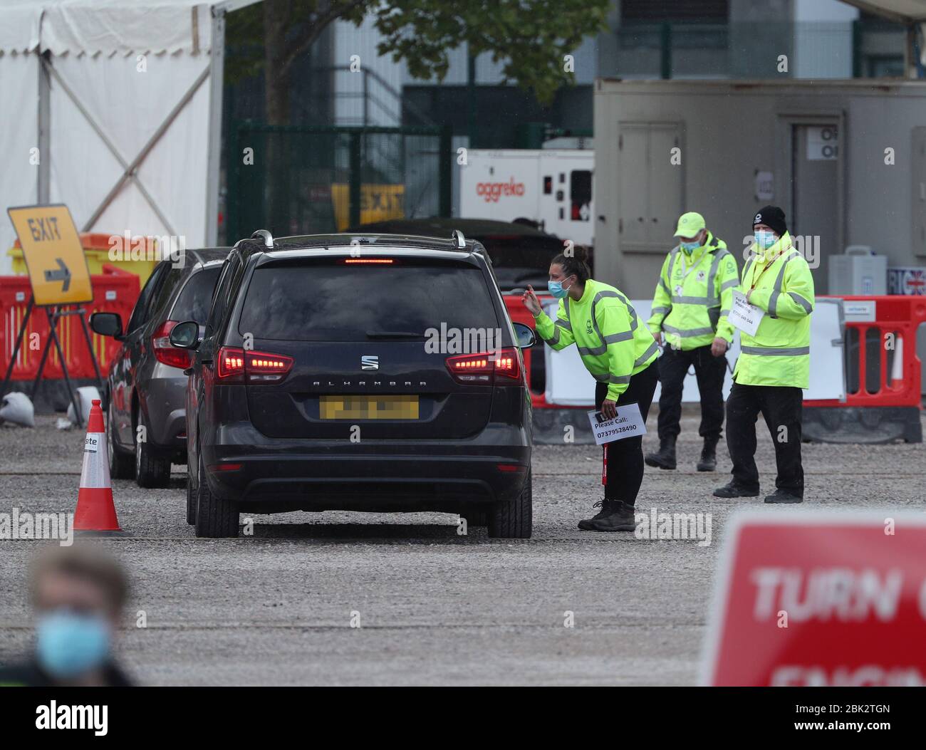 NOTA: LE TARGHE SONO STATE PIXELATED DAL personale del PA PICTURE DESK parlare con una persona che lascia una stazione di test drive-thru per i coronavirus nel parcheggio del Twickenham Stadium a sud-ovest di Londra. Foto Stock