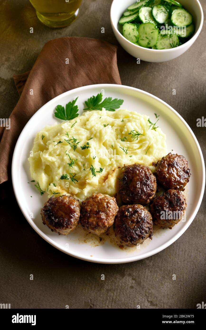 Tagli di carne tritati con purè di patate sul piatto su fondo marrone. Vista ravvicinata Foto Stock