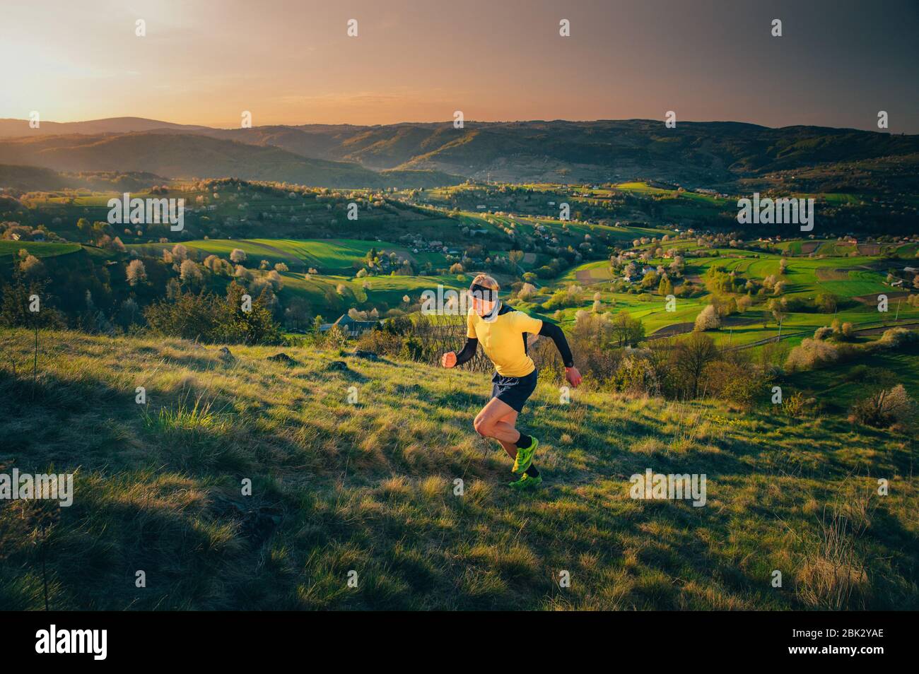 Esercizio mattutino in calda luce del sole, Athlete correre nella natura primaverile. Hrinova, Slovacchia Foto Stock