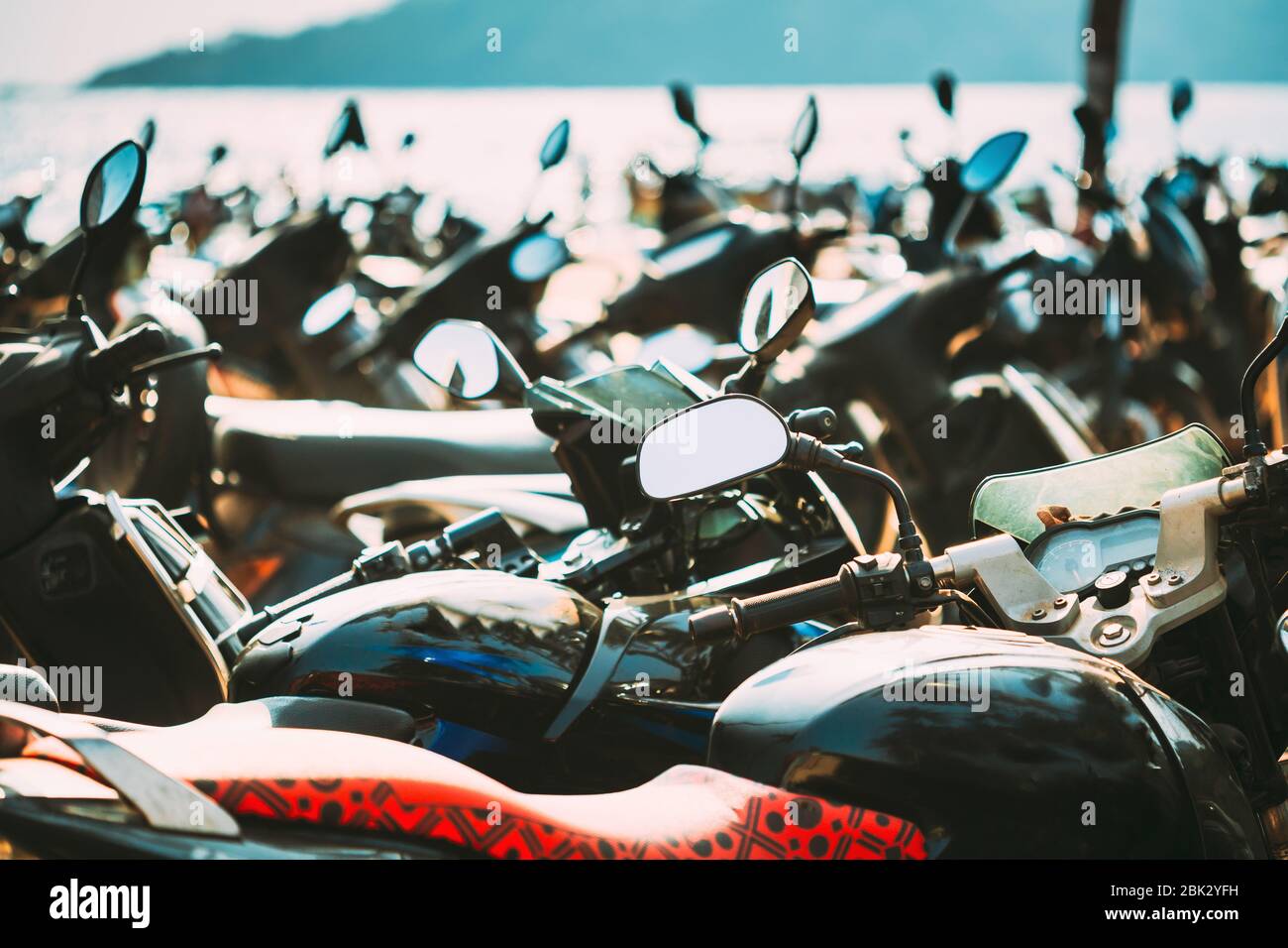Moto, moto scooter parcheggiati in fila in strada della città. Primo piano dei dettagli. Biciclette. Foto Stock