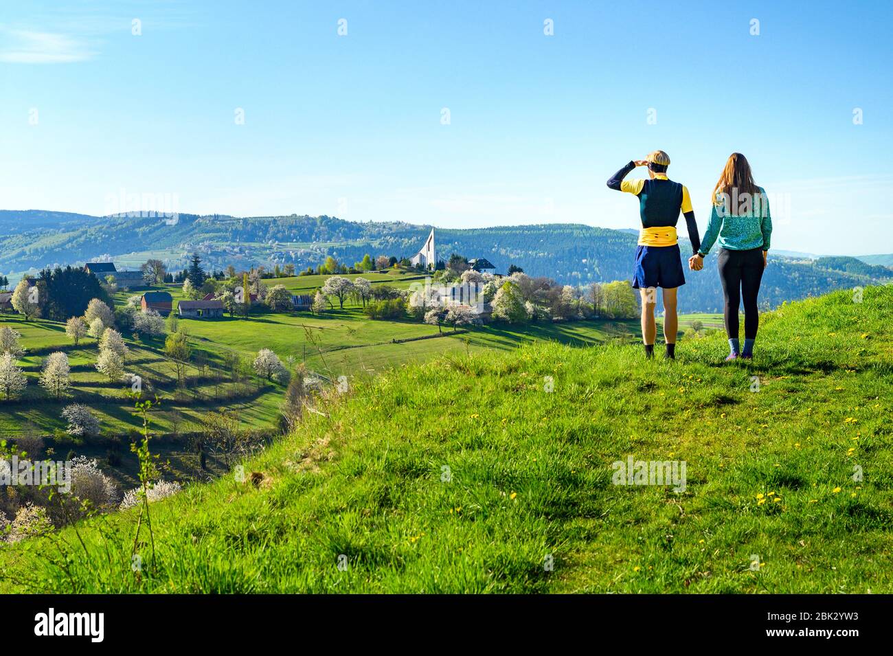 Coppia in piedi insieme in cima alla collina sopra il bellissimo paesaggio verde primavera mattina Foto Stock