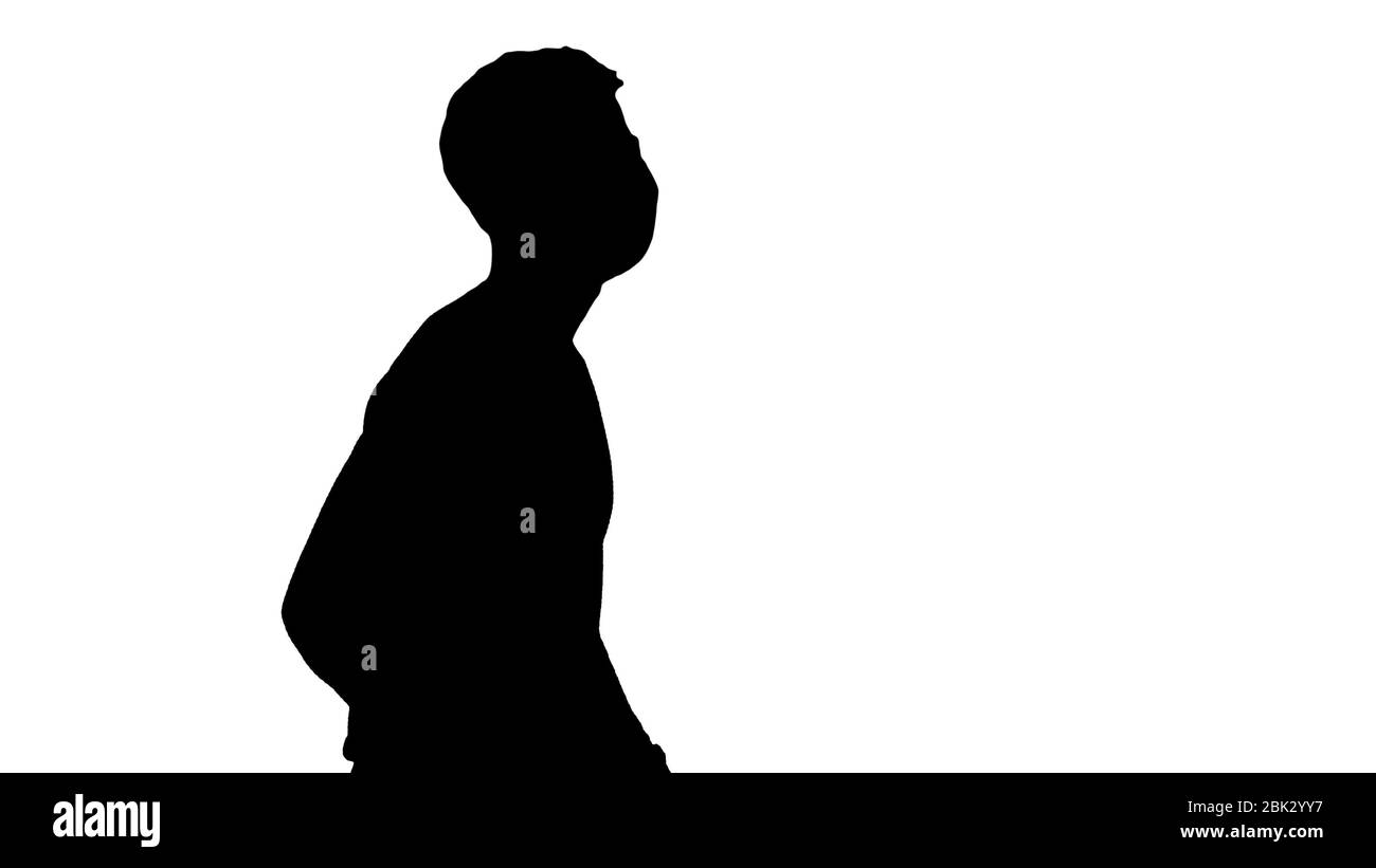 Silhouette giovane non vedente con lunghe passeggiate in canna e maschera medica. Foto Stock