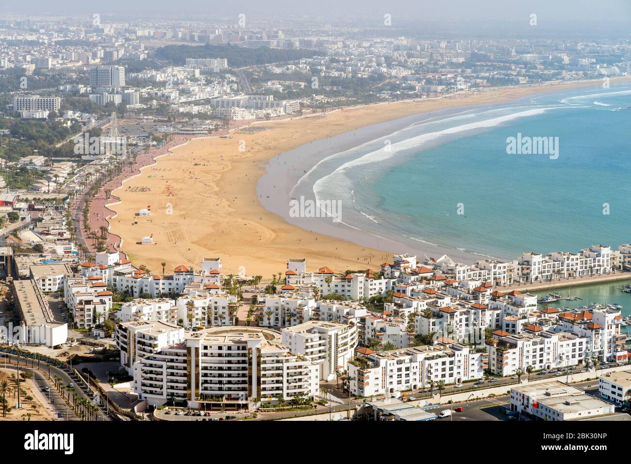 Architettura moderna e bianca che circonda una spiaggia di sabbia incredibilmente ampia ad Agadir, Marocco, Nord Africa Foto Stock