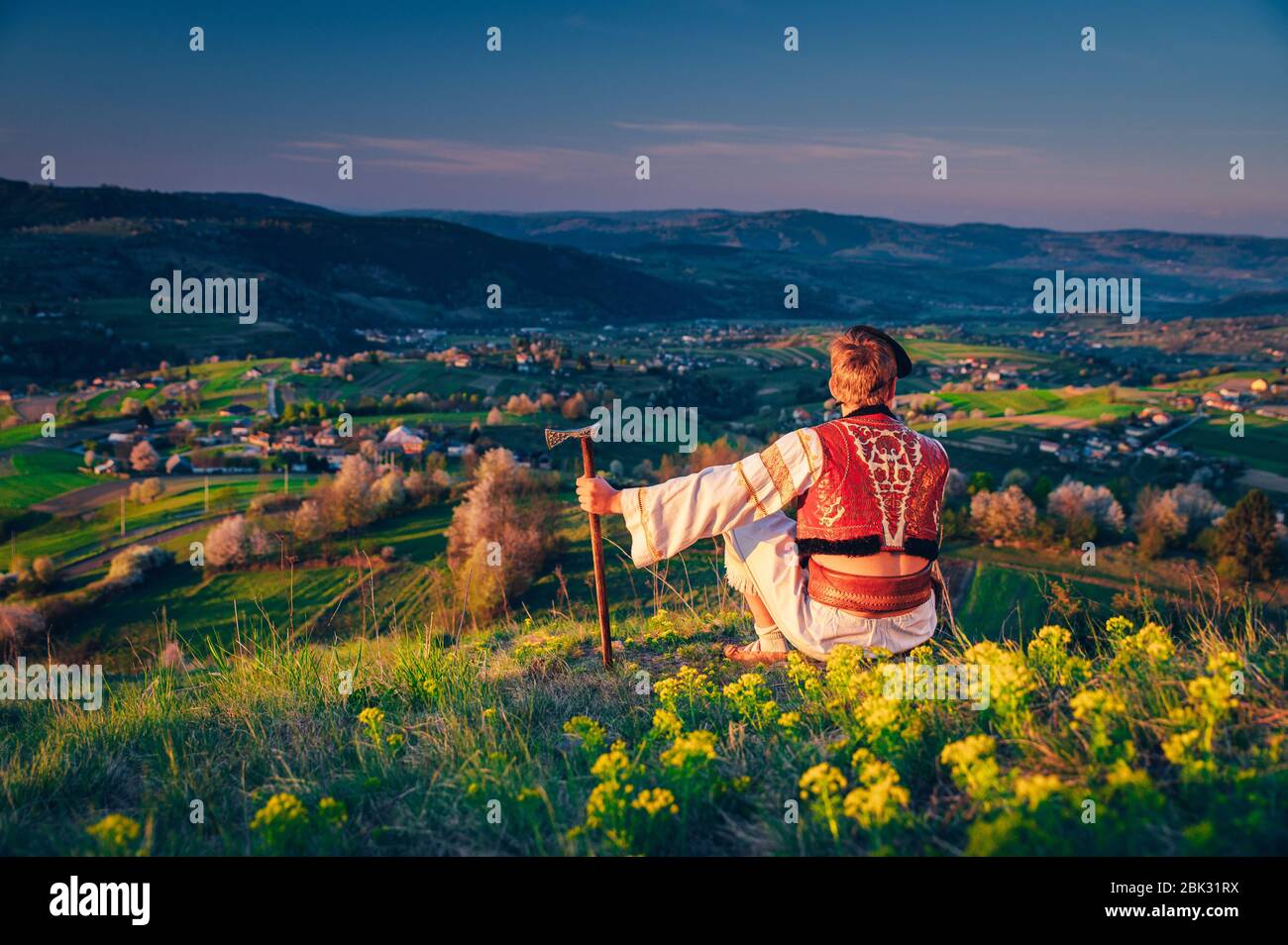 Uomo in tradizionale abito folk slovacco seduta nella natura primaverile. Hrinova slovacchia Foto Stock