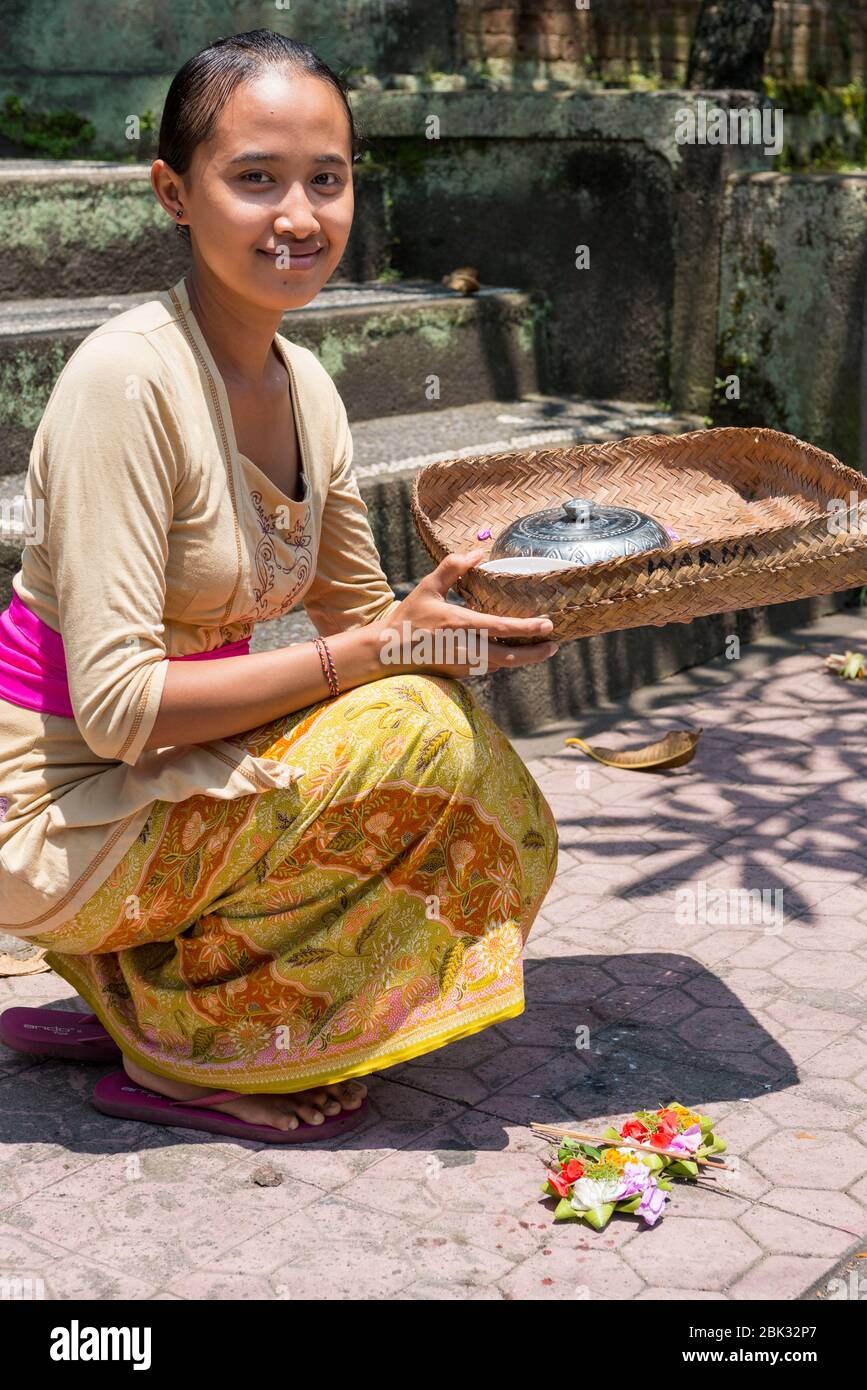 Giovane donna balinese offre le sue offerte quotidiane, canang sari, agli dei, Ubud, Bali, Indonesia Foto Stock